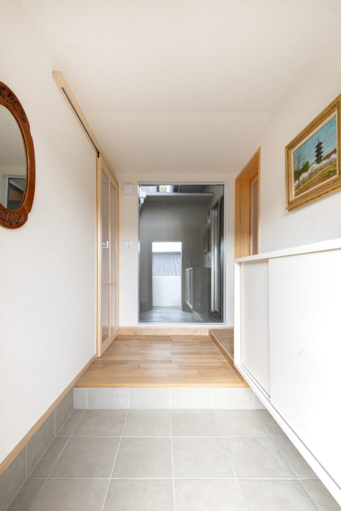 新たに計画した玄関。正面の中庭まで視界が抜け、空間に広がりを感じます。